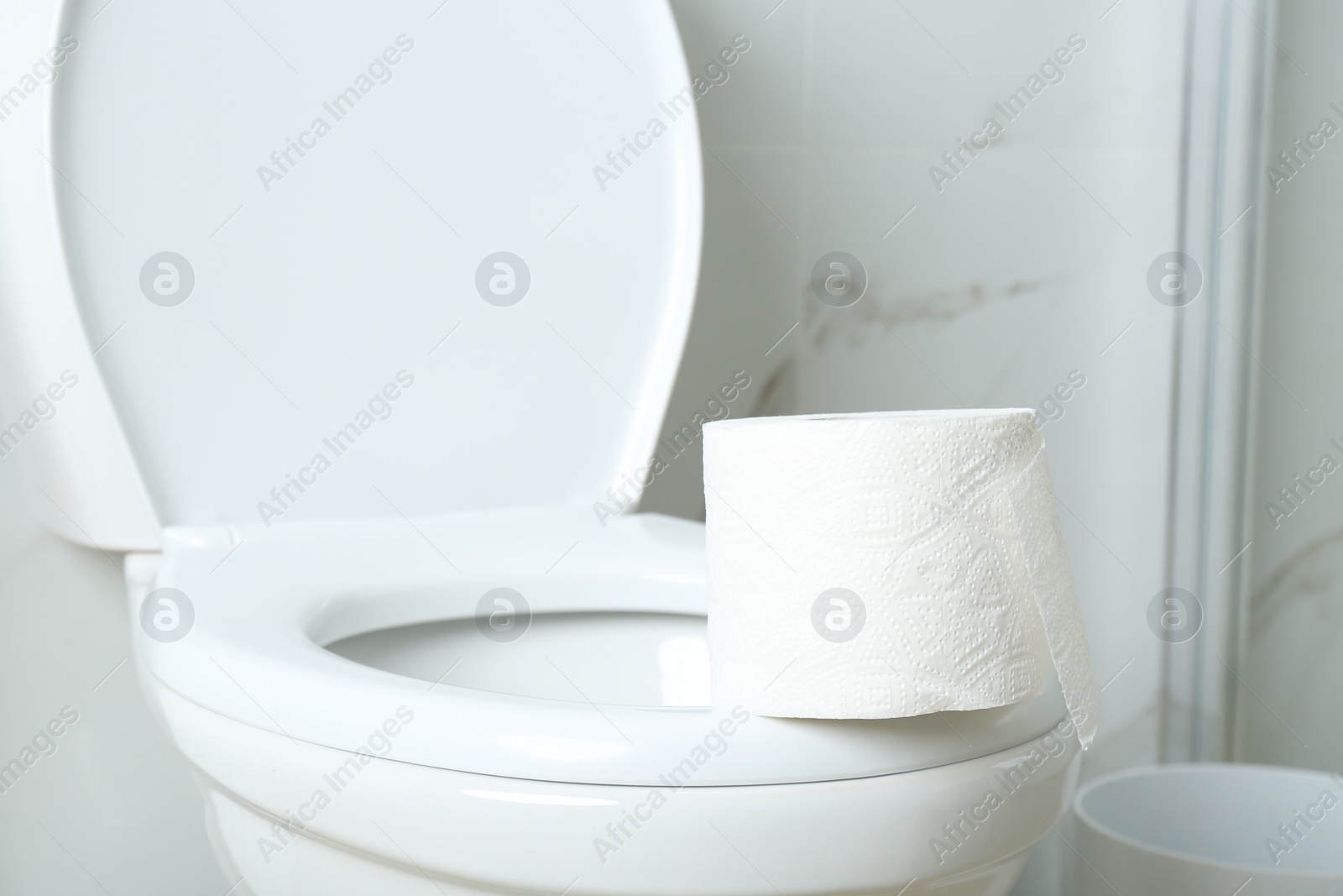 Photo of New paper roll on toilet bowl in bathroom