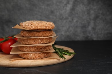 Raw vegan cutlets with breadcrumbs on black table, space for text