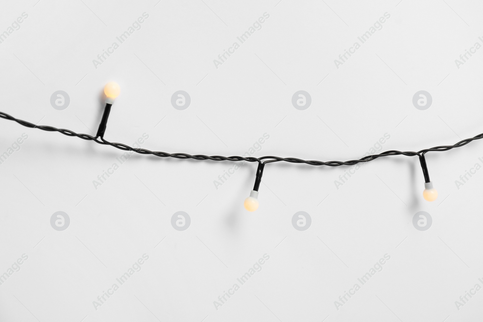 Photo of Beautiful Christmas lights on white background, top view