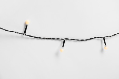 Photo of Beautiful Christmas lights on white background, top view