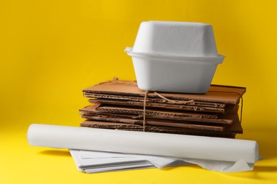 Heap of waste paper on yellow background