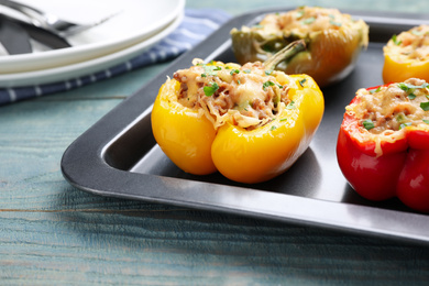 Photo of Tasty stuffed bell peppers on blue wooden table, closeup