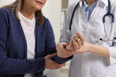 Arthritis symptoms. Doctor examining patient's wrist in hospital, closeup