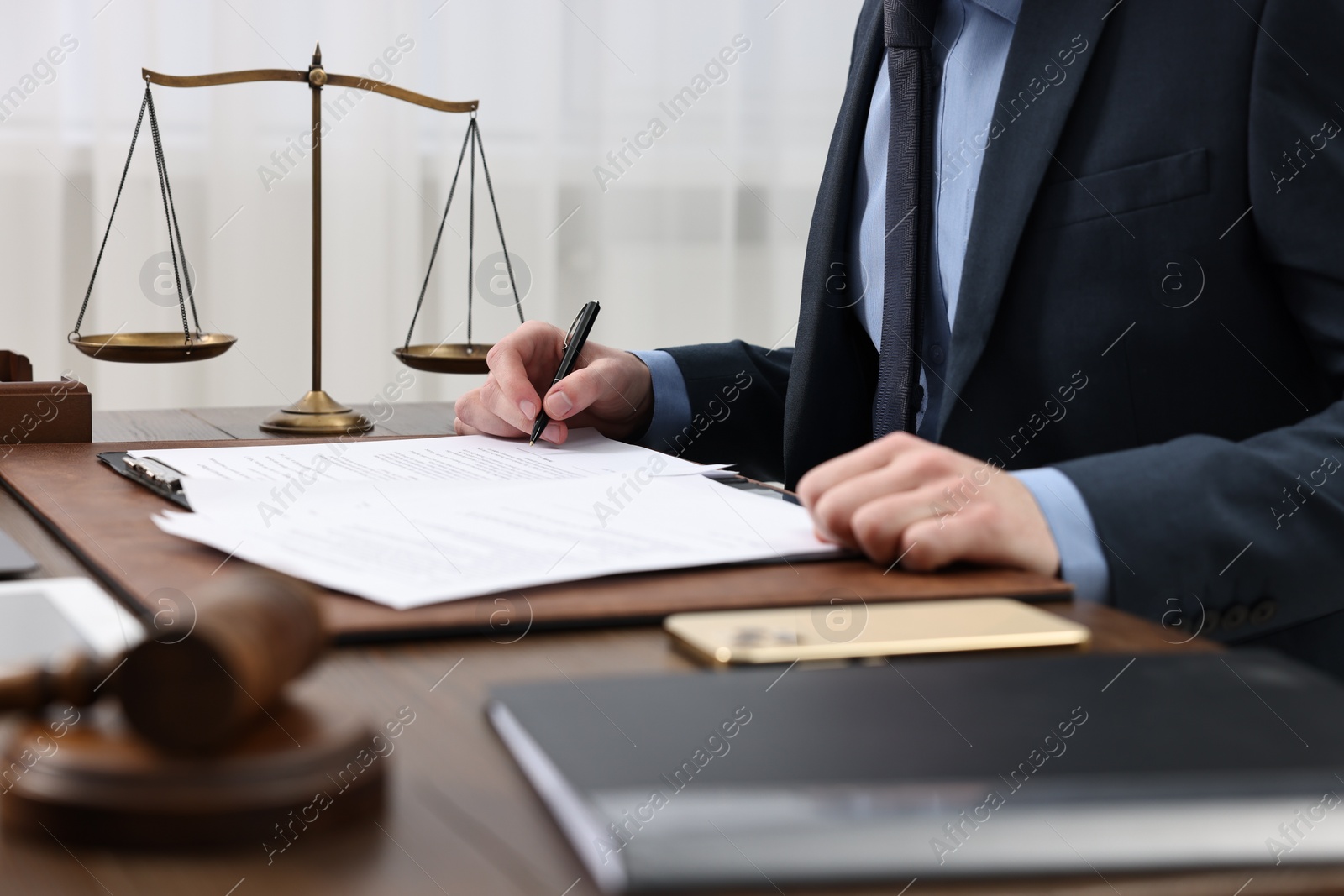 Photo of Lawyer working with documents at table indoors, closeup