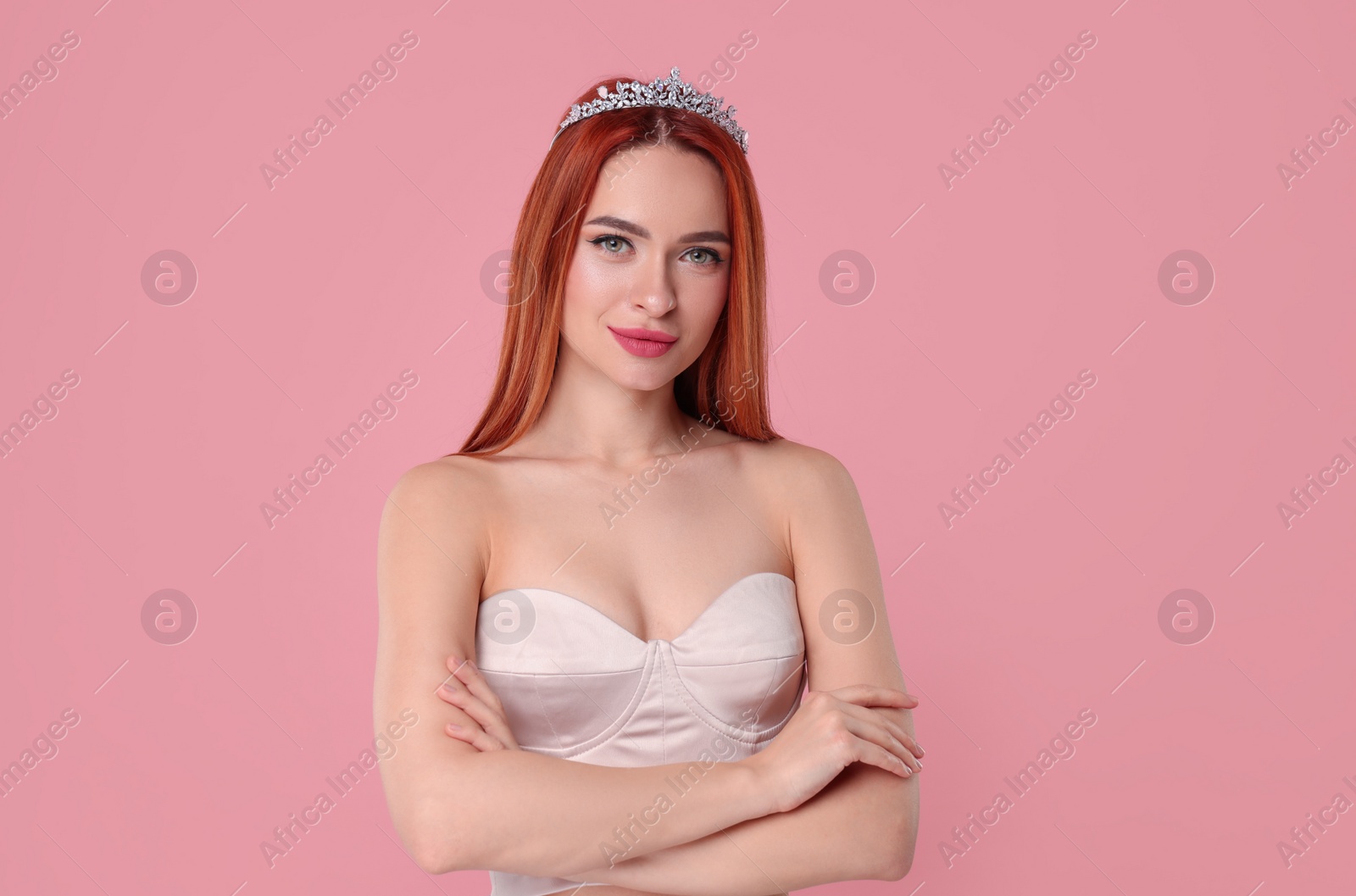 Photo of Beautiful young woman with tiara on pink background