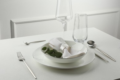 Photo of Stylish setting with cutlery and napkin on white textured table