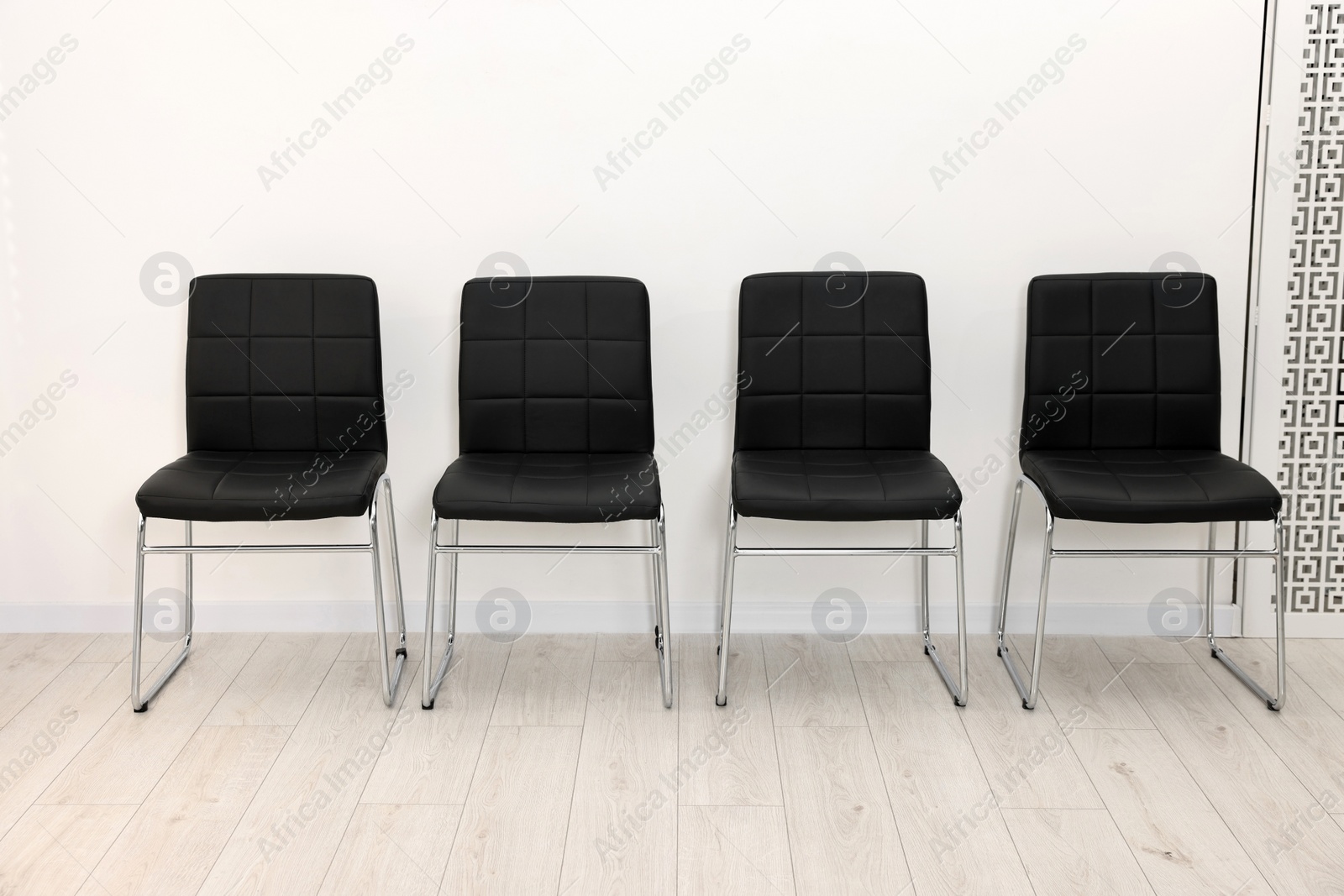 Photo of Many chairs near white wall in waiting area indoors