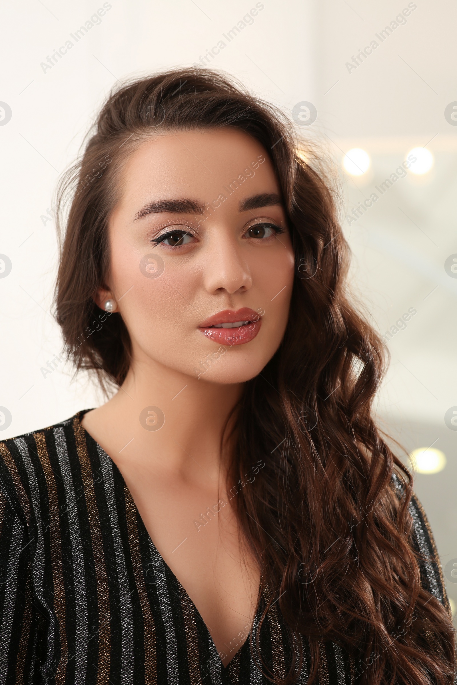 Photo of Portrait of beautiful young woman with wavy brown hair indoors