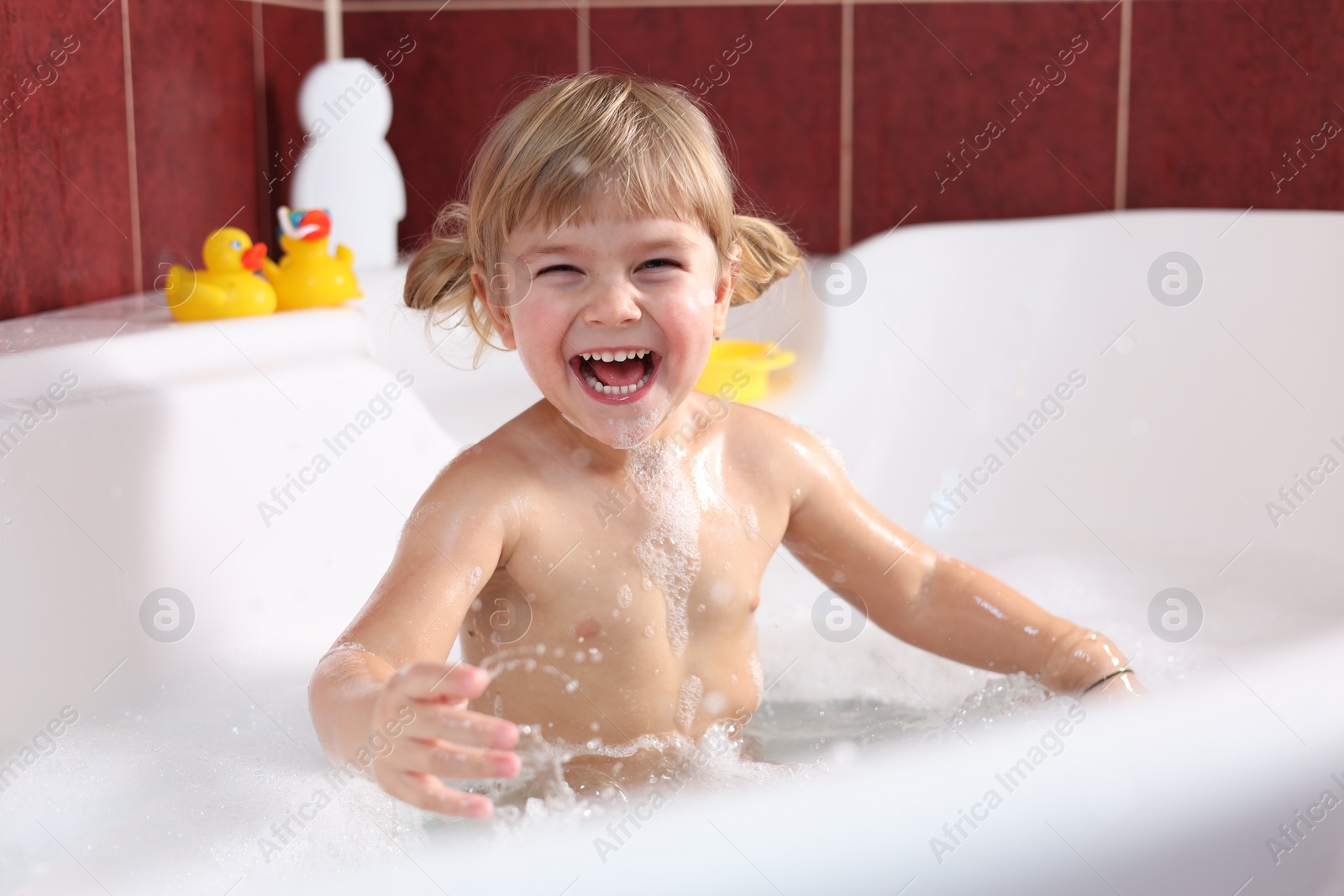 Photo of Happy girl bathing in tub at home