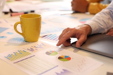 Photo of Man working with charts at table, closeup. Startup project