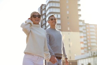 Photo of Couple in stylish sweaters on city street
