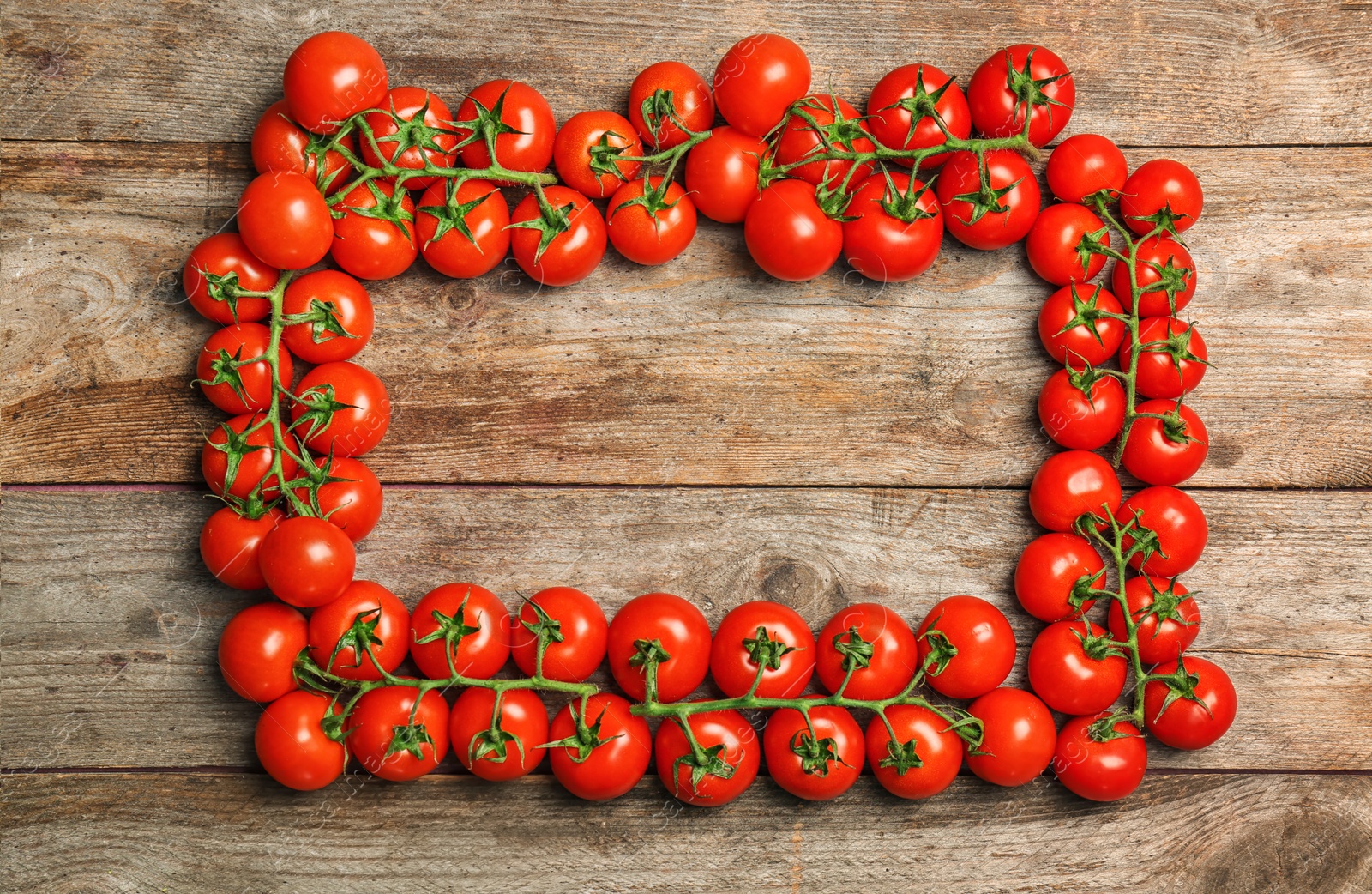 Photo of Frame made of ripe tomatoes on wooden background