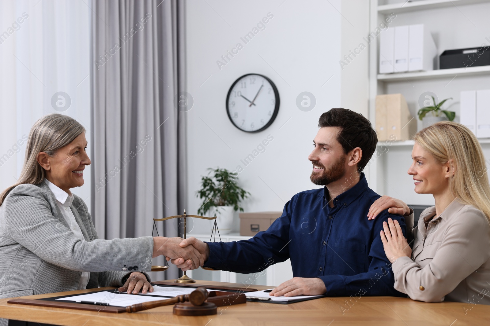 Photo of Lawyer shaking hands with clients in office