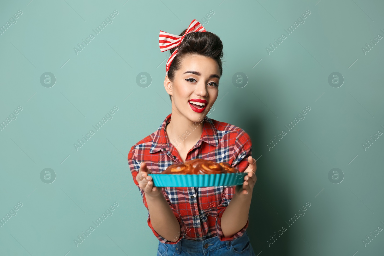 Photo of Funny young housewife with homemade pastry on color background