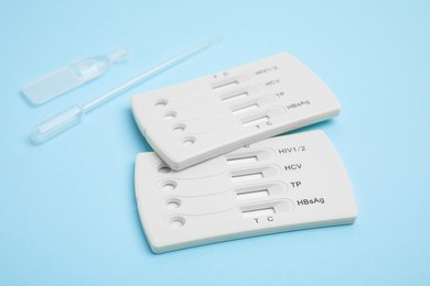 Photo of Disposable express test kit for hepatitis on light blue background