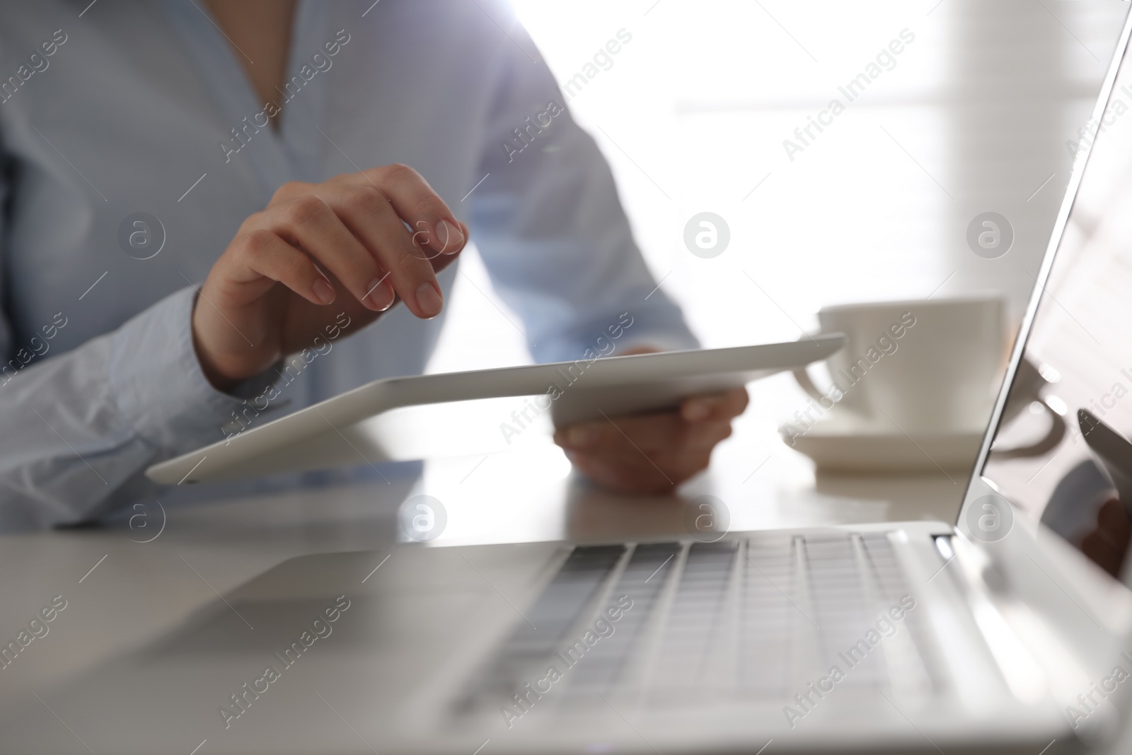 Photo of Businesswoman working with modern tablet at table in office, closeup
