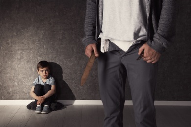 Photo of Man with unzipped pants and scared little boy indoors. Child in danger