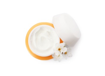 Photo of Face cream in jar and flowers on white background, top view