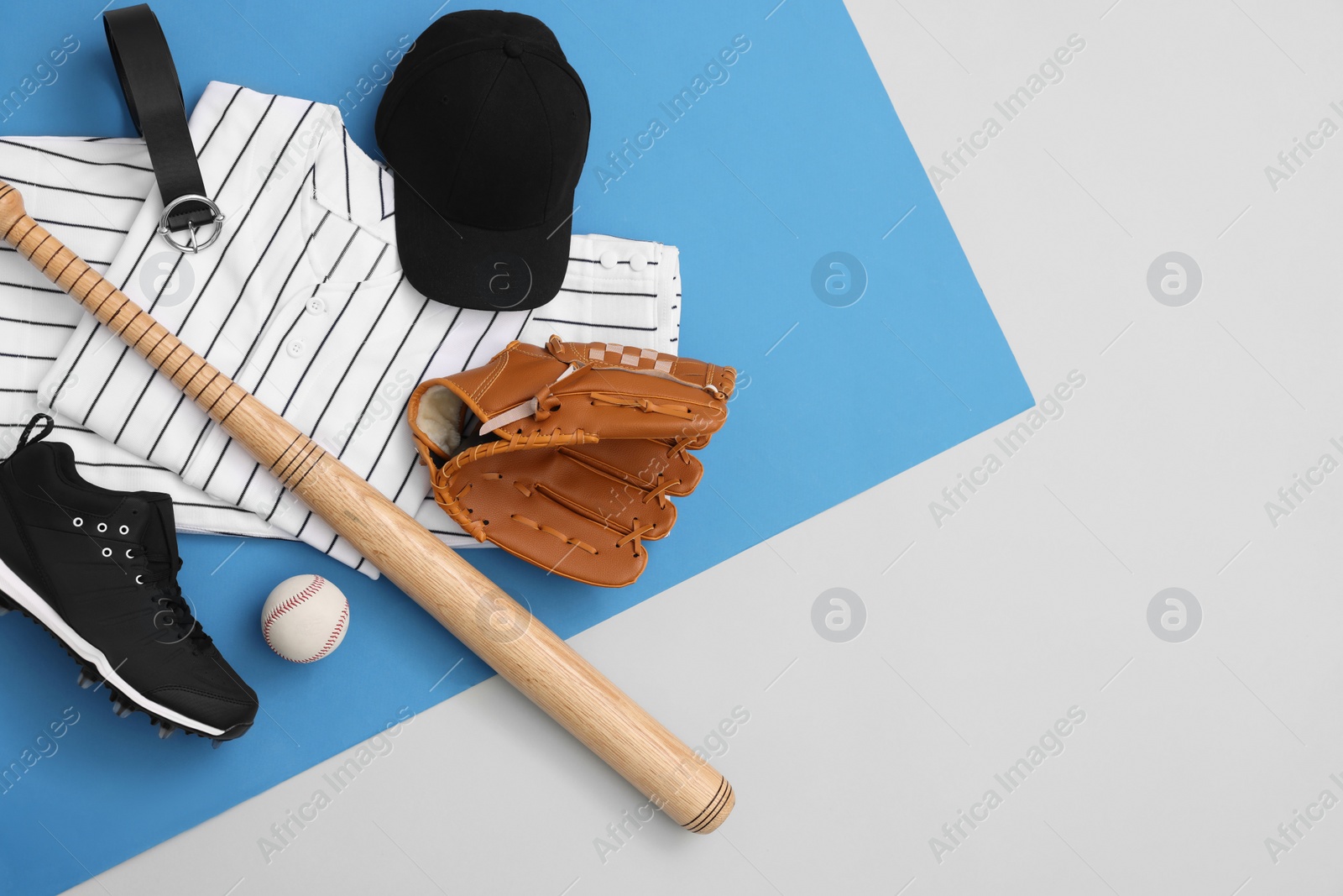 Photo of Flat lay composition with baseball uniform and sports equipment on color background. Space for text