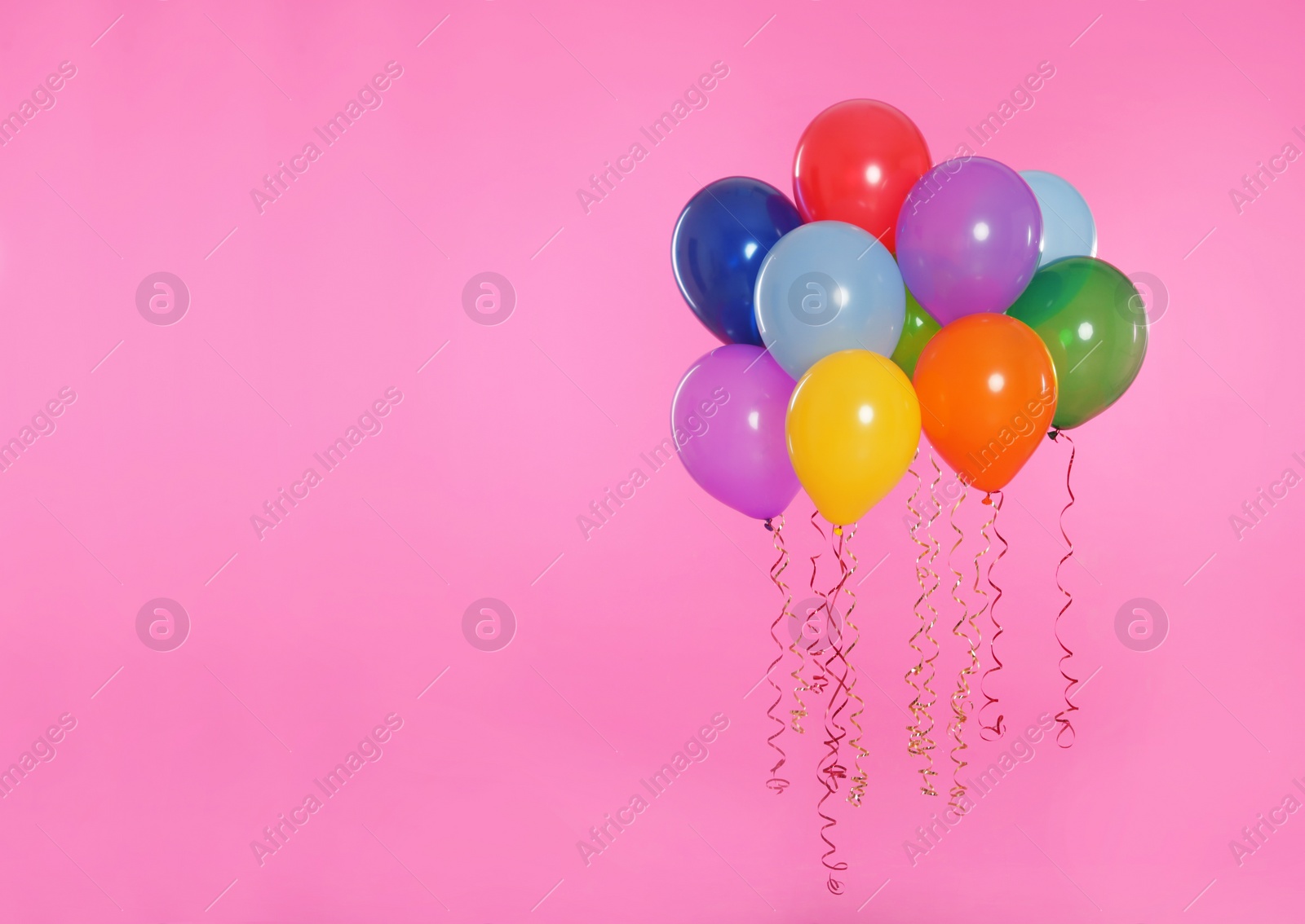 Photo of Many bright balloons floating on color background. Space for text