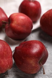 Photo of Fresh red apples on grey textured table, closeup