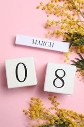 Photo of International Women's day - 8th of March. Wooden block calendar and beautiful flowers on pink background, flat lay