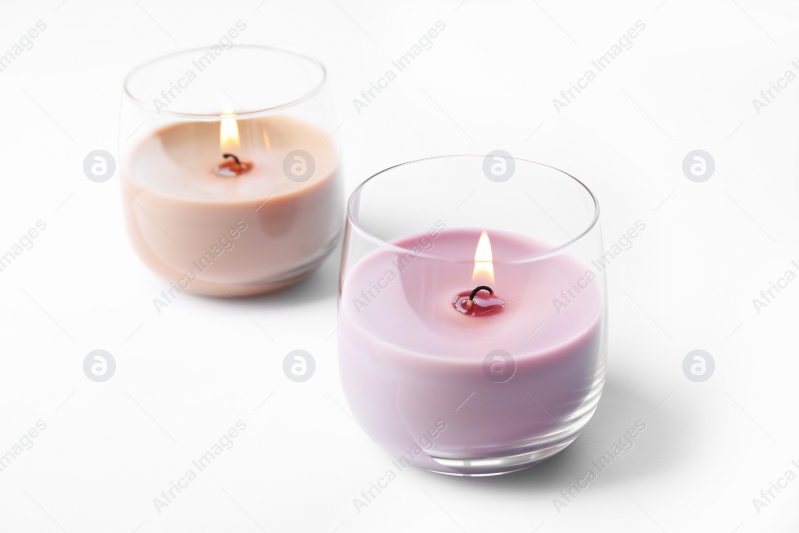 Photo of Color wax candles in glass holders isolated on white