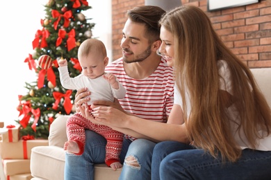 Photo of Happy couple with baby celebrating Christmas together at home