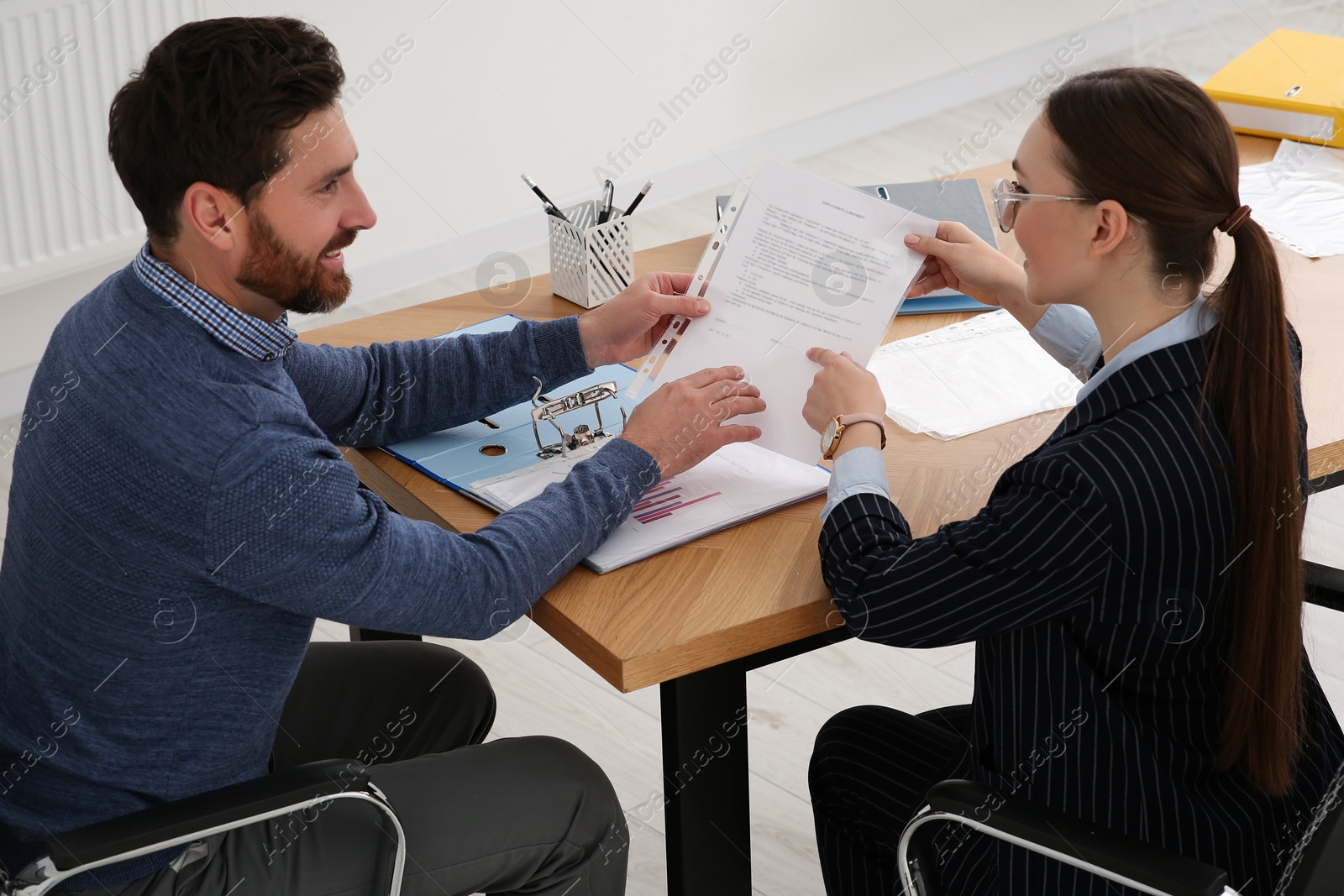 Photo of Businesspeople working with documents at wooden table in office