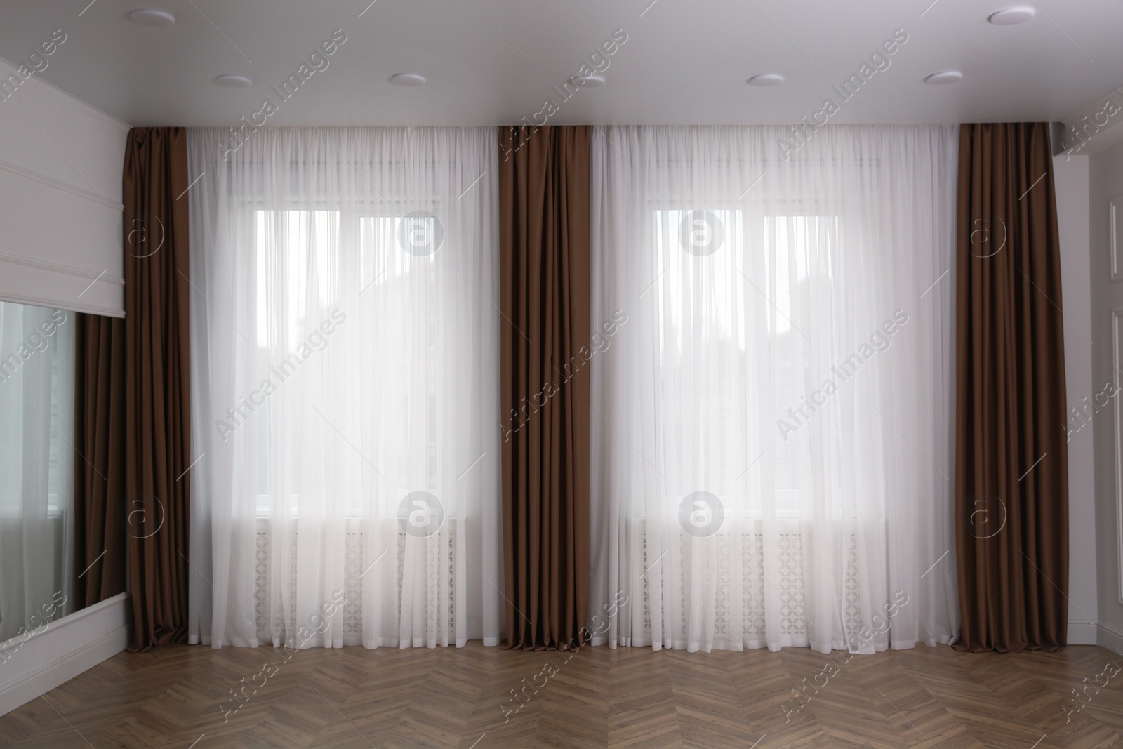 Photo of Windows with elegant curtains in room. Interior design