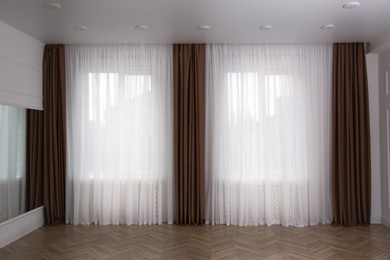 Photo of Windows with elegant curtains in room. Interior design
