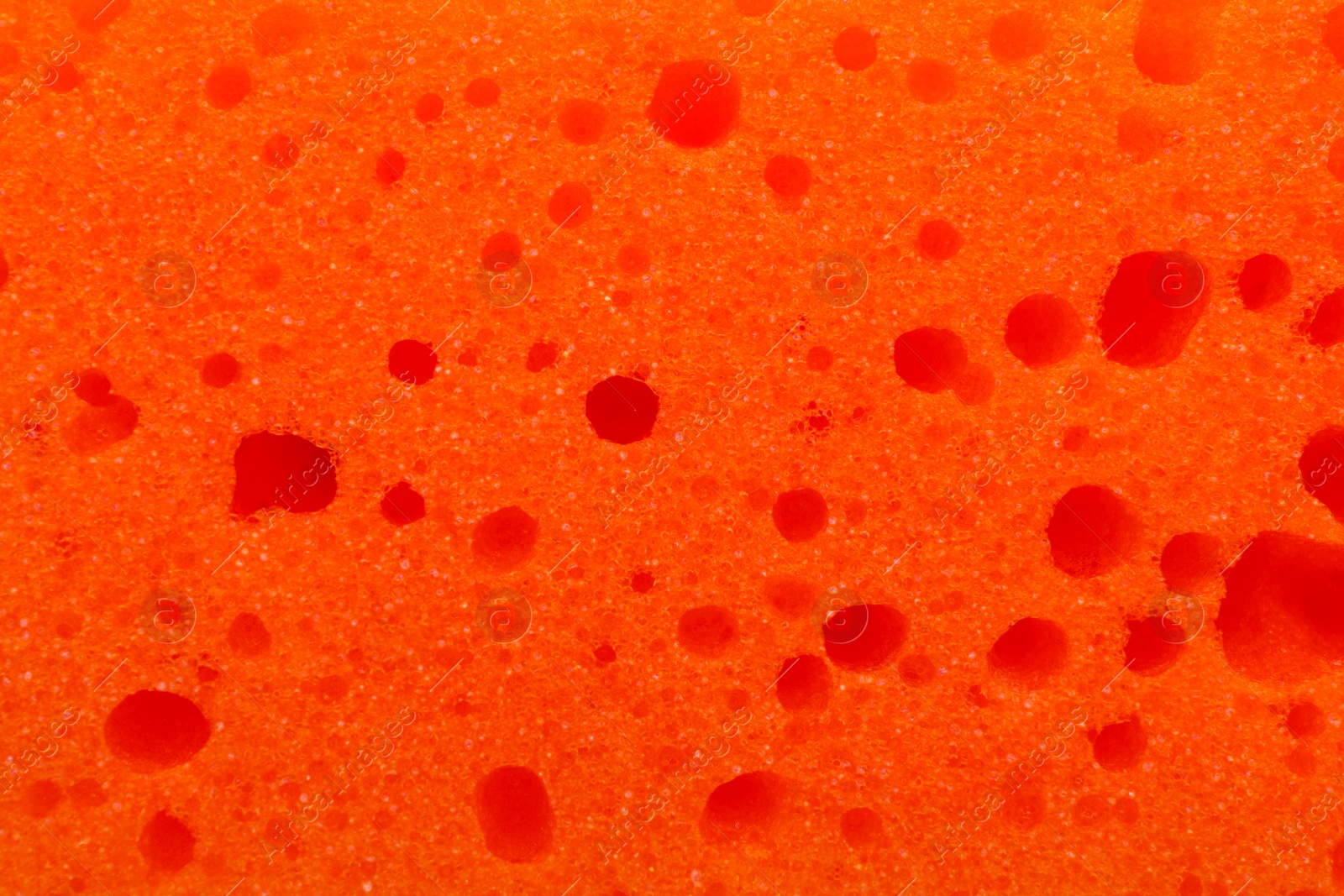 Photo of Orange cleaning sponge as background, top view