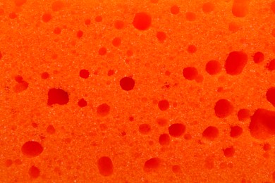 Orange cleaning sponge as background, top view