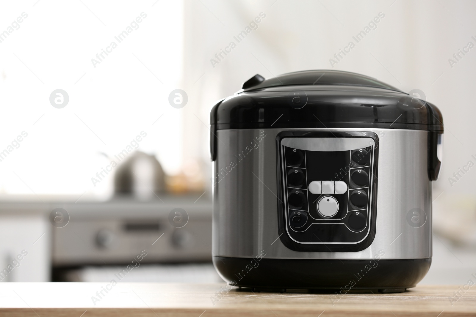 Photo of Modern electric multi cooker on table in kitchen. Space for text