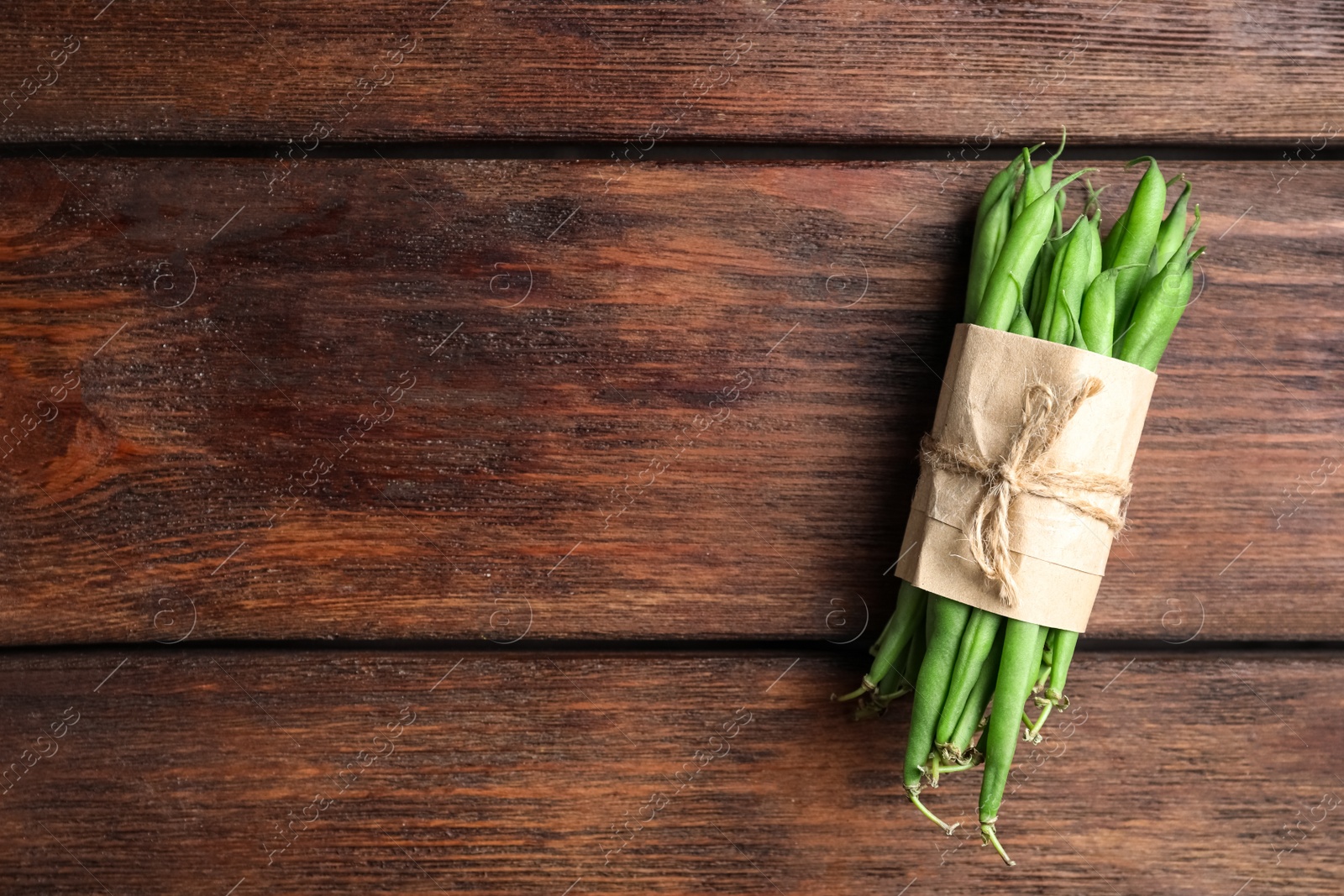 Photo of Fresh green beans on wooden table, top view. Space for text