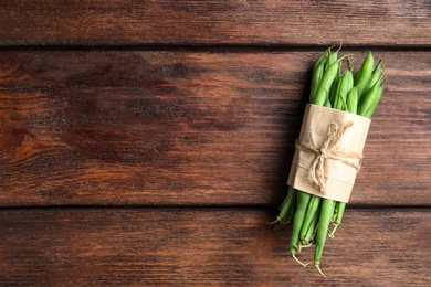 Fresh green beans on wooden table, top view. Space for text