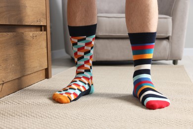 Photo of Man in different stylish socks indoors, closeup