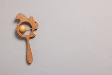 Photo of Baby accessory. Wooden rattle on grey background, top view. Space for text