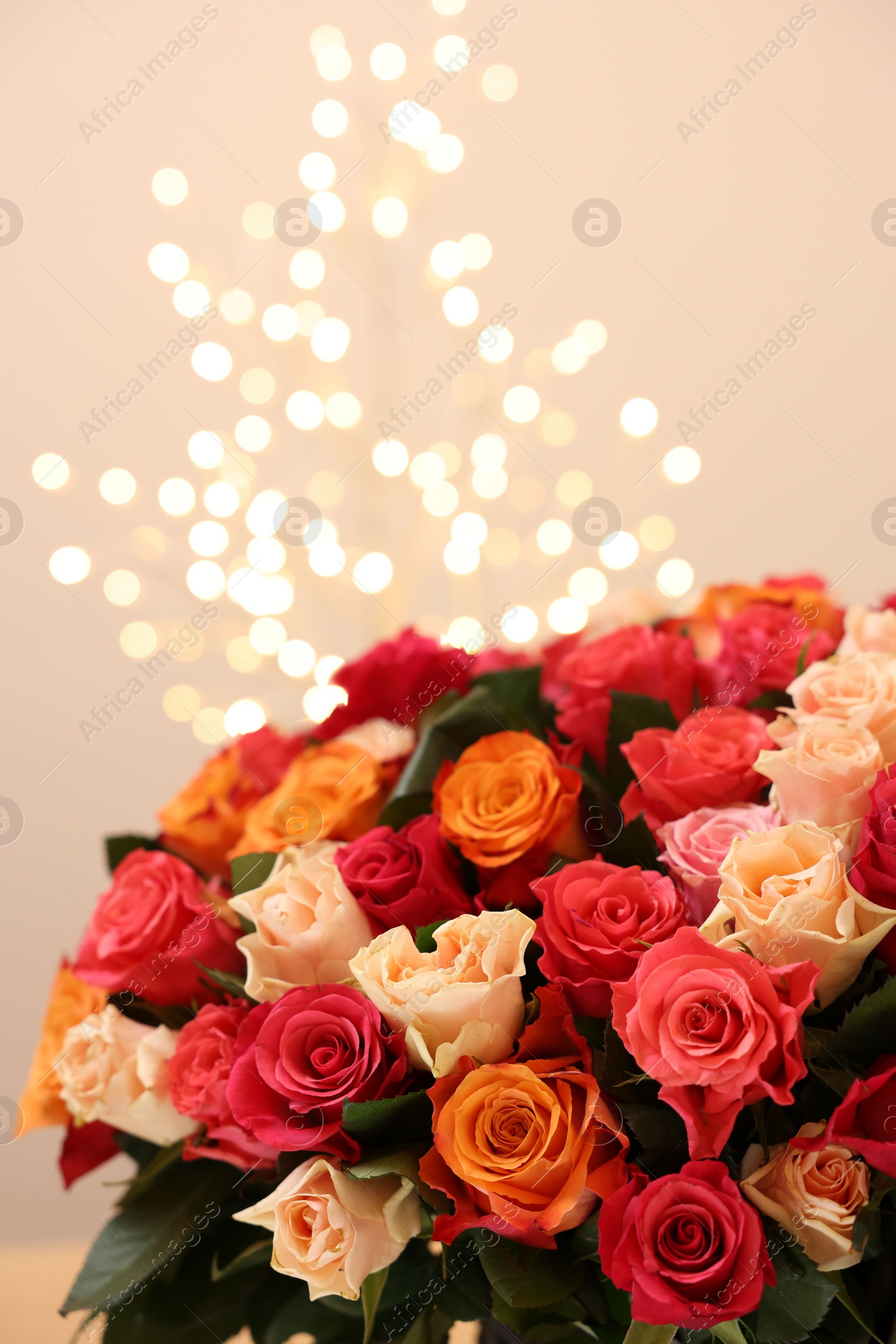 Photo of Beautiful bouquet of colorful roses on beige background