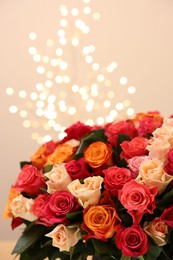 Beautiful bouquet of colorful roses on beige background