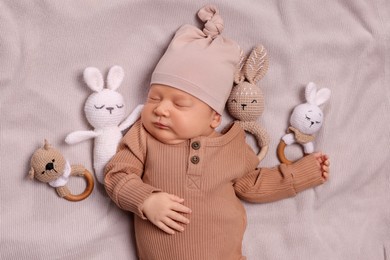 Cute newborn baby sleeping with toys on blanket, top view