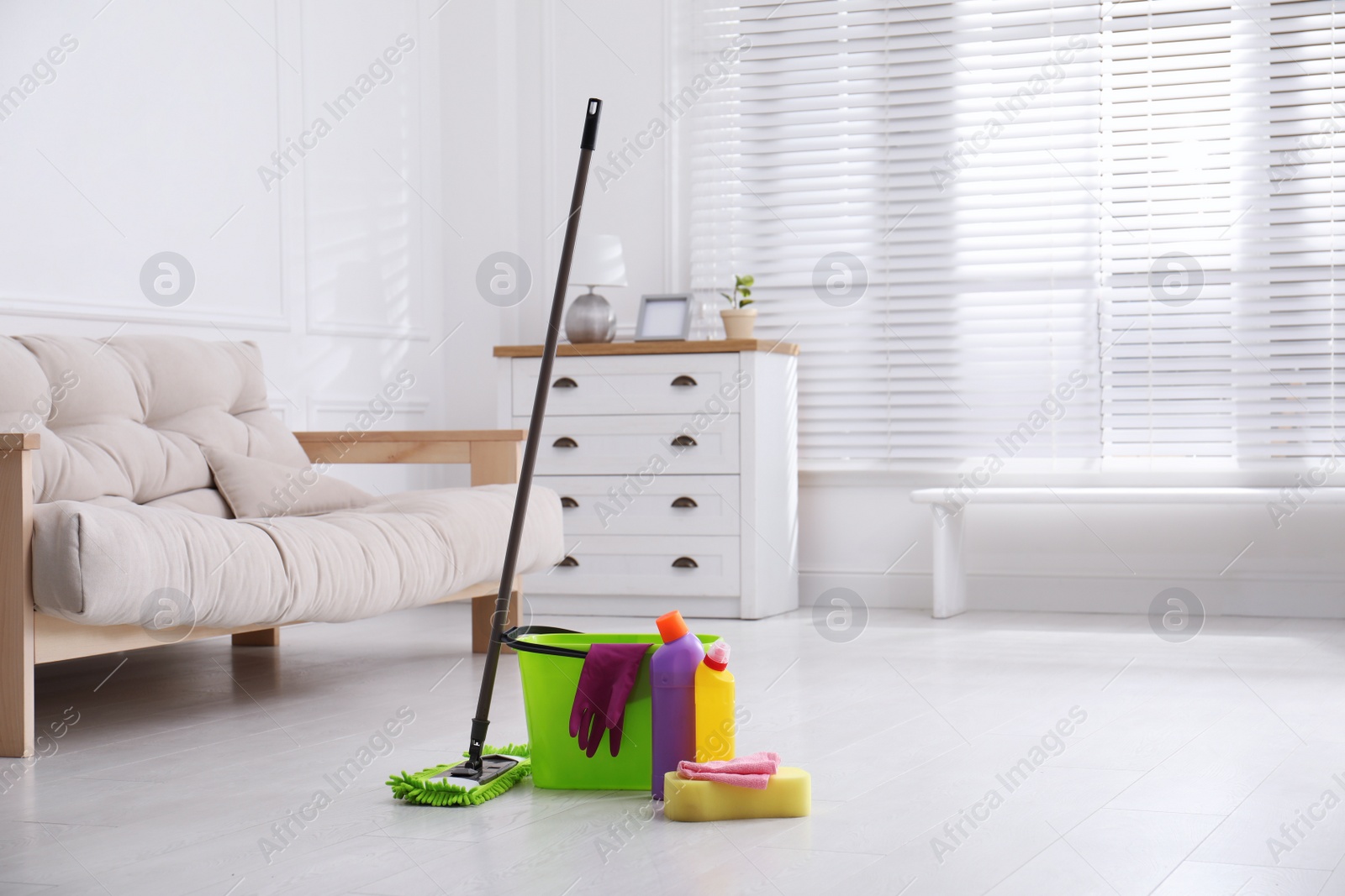 Photo of Mop and cleaning supplies on floor in room