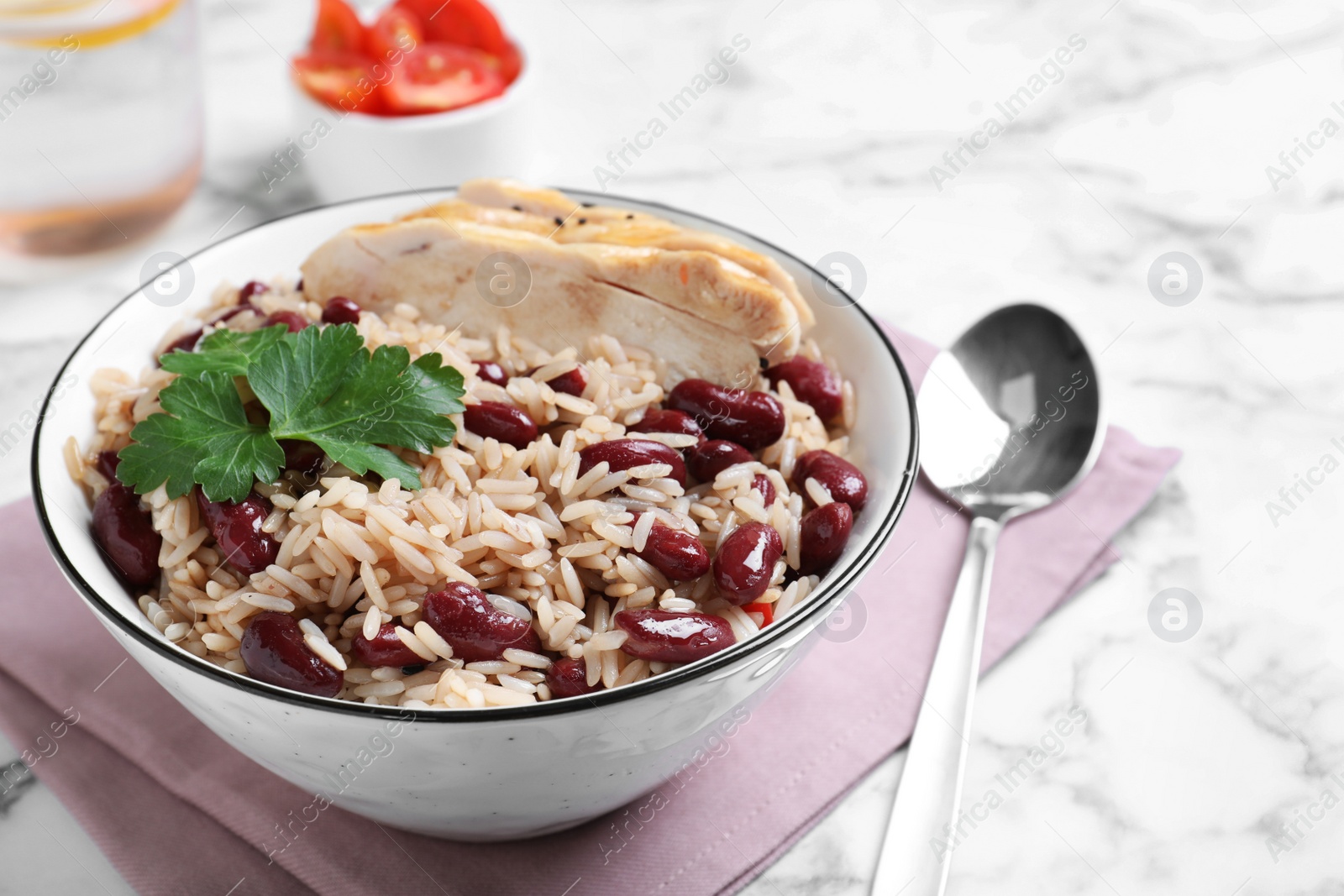 Photo of Delicious rice with beans and meat served on white marble table, closeup