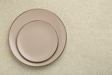 Photo of Beautiful ceramic plates on beige table, top view. Space for text