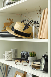 White shelving unit with straw hat and different decorative elements