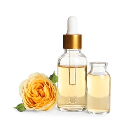 Photo of Bottles of rose essential oil and flower isolated on white