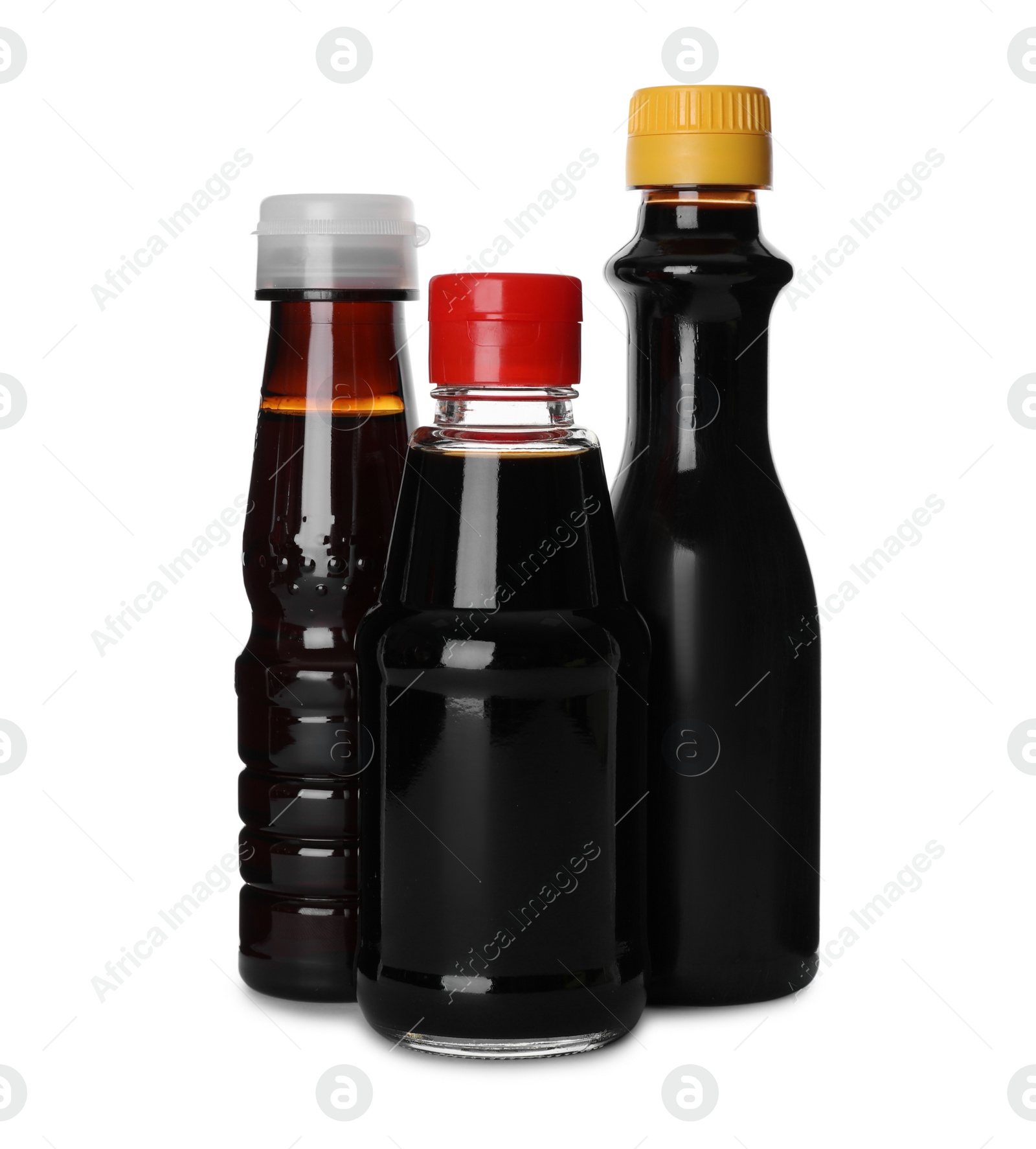 Photo of Bottles of tasty soy sauce isolated on white