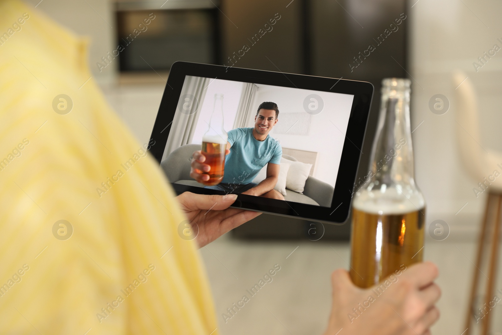 Photo of Friends having video chat and drinking beer together. Online meeting during coronavirus quarantine