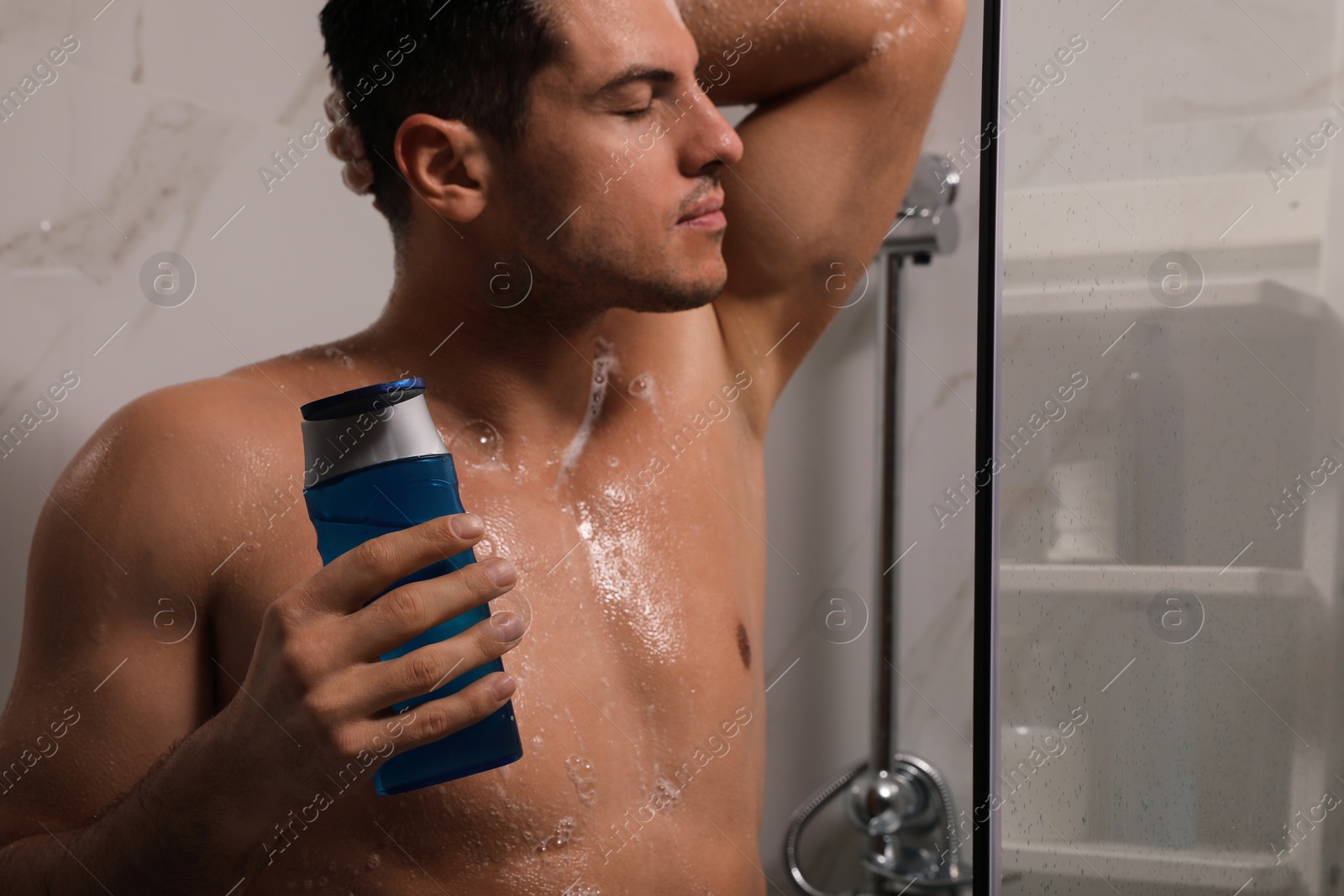 Photo of Man using gel in shower at home