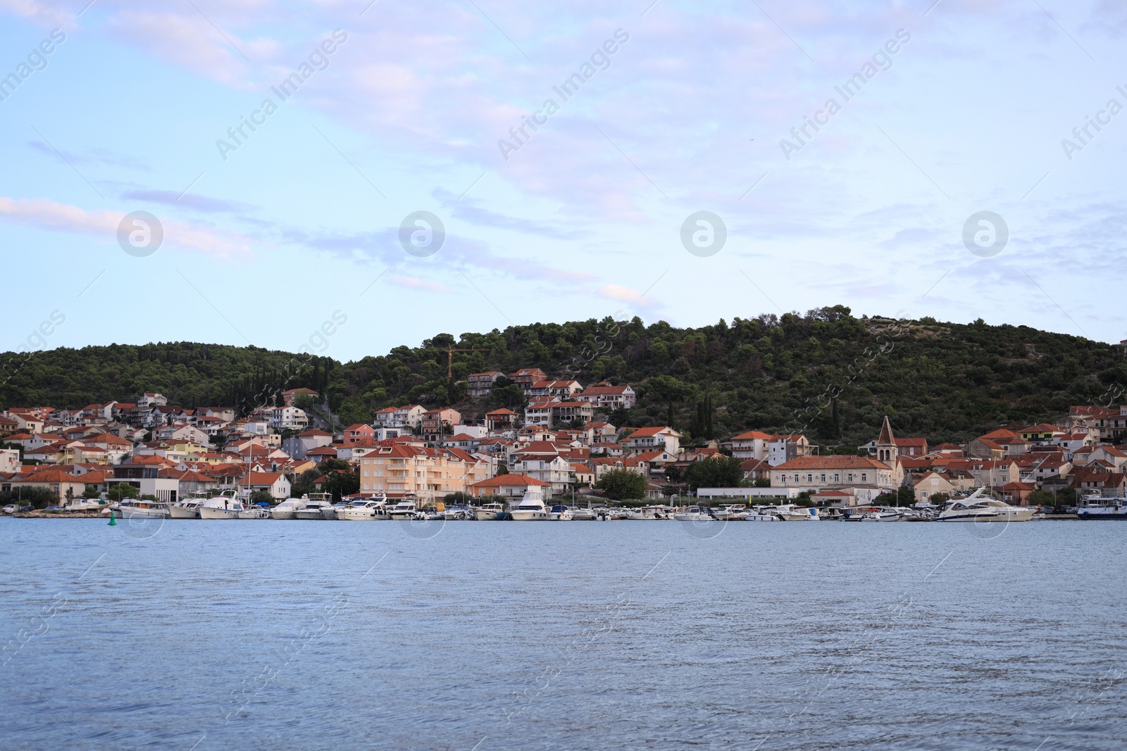 Photo of Picturesque view of town, moored boats and sea on cloudy day